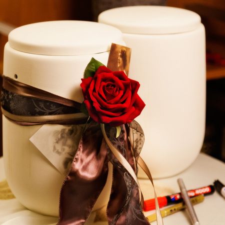 2 gleiche Urnen, eine davon mit Rosen verziert