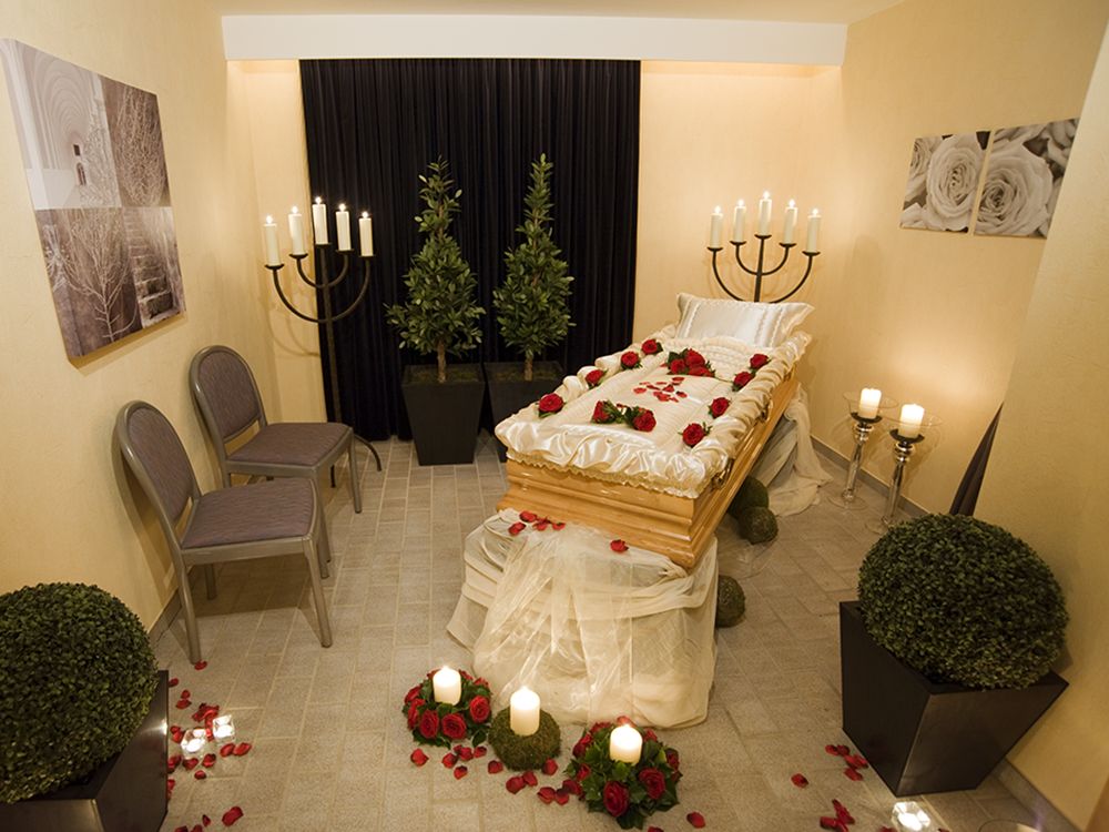Verabschiedungsraum mit einem leeren offenem Sag und Blumenschmuck und Kerzen